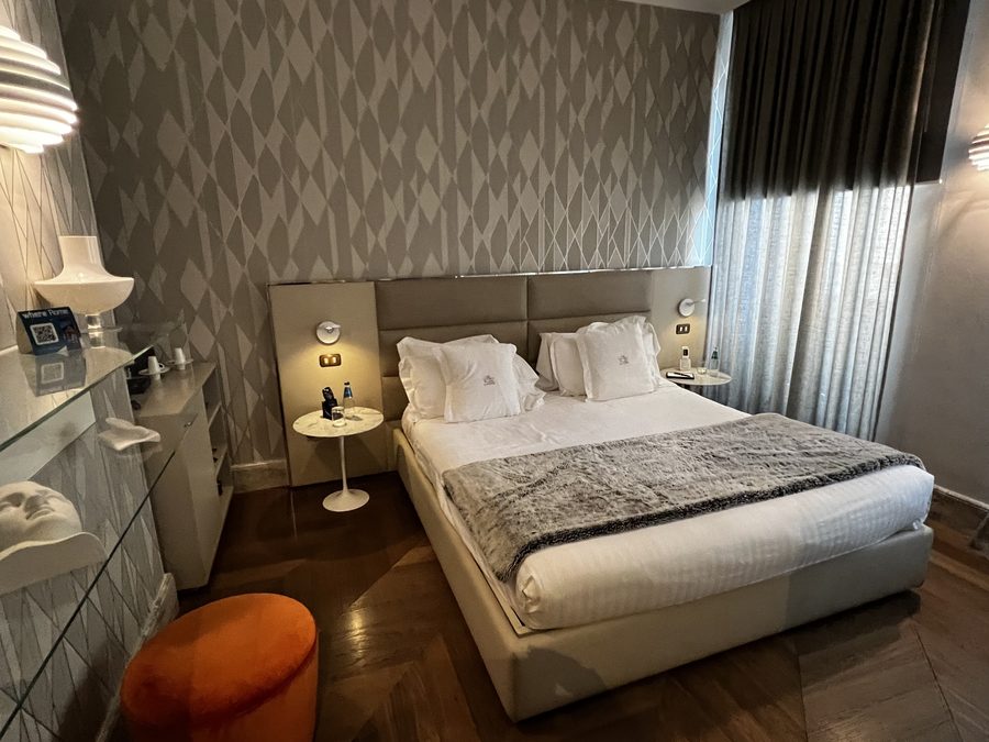 Guest room with a king bed and herringbone floors at Palazzo Manfredi in Rome