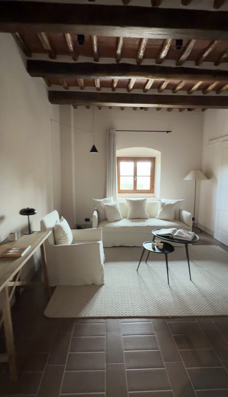 Sitting room with white linen sofa and arched window at Pieve Aldina