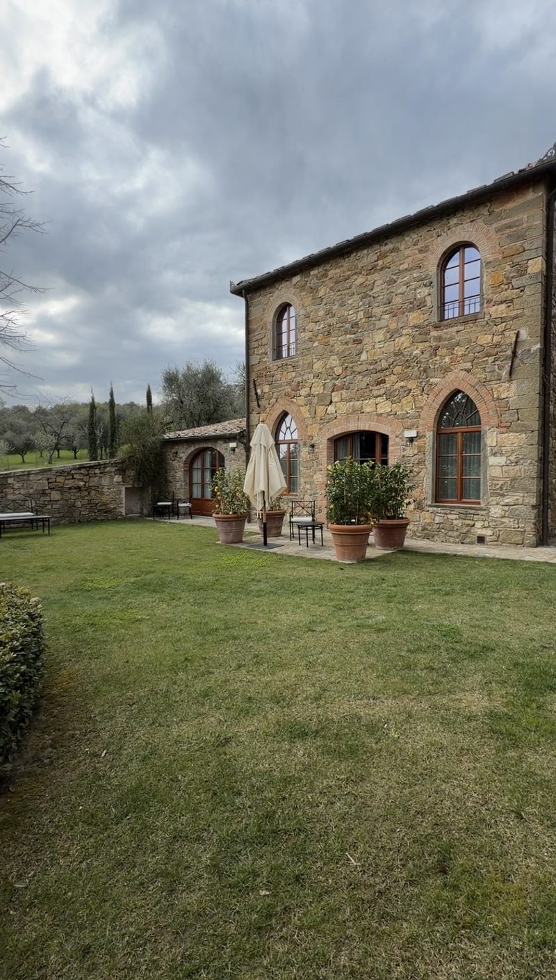 Stone villa with arched windows and potted lemon trees at Pieve Aldina